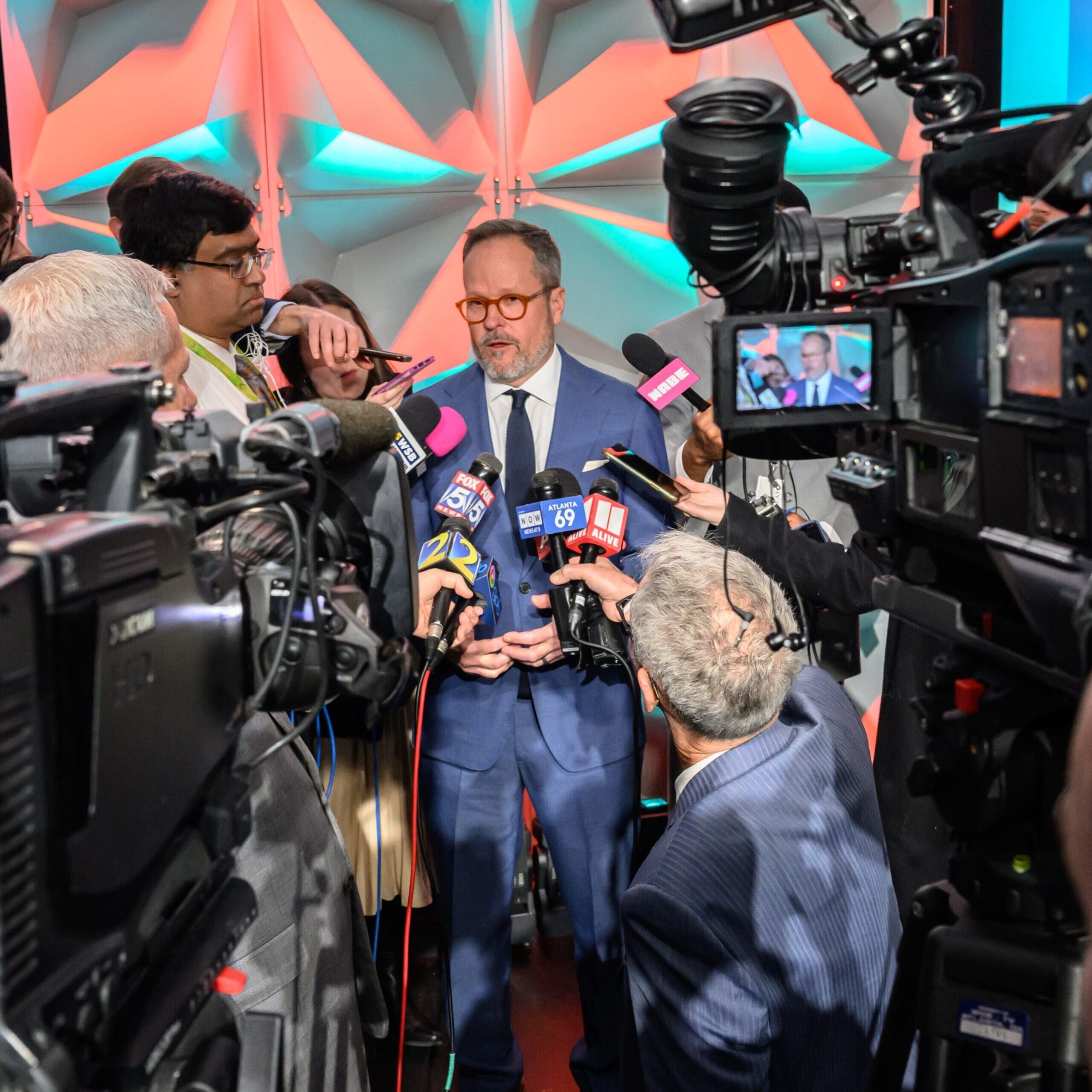 Chris Clark speaking to reporters and news cameras at a media scrum